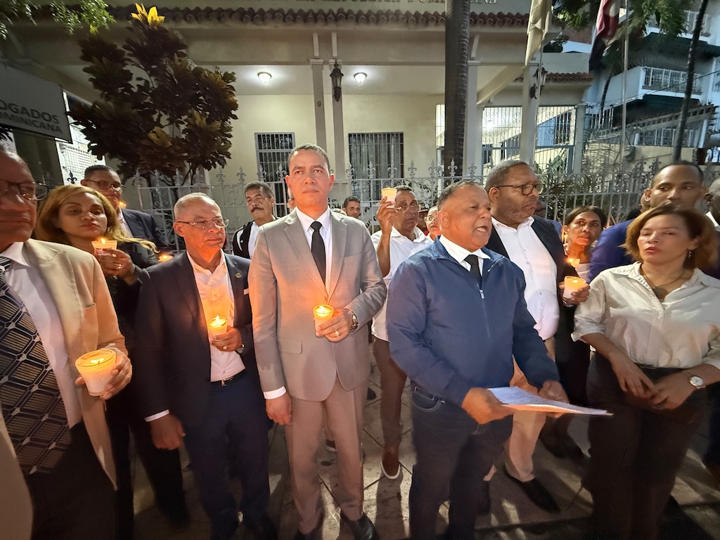 Abogados sostienen velas encendidas frente a la sede del Colegio de Abogados durante una manifestación.