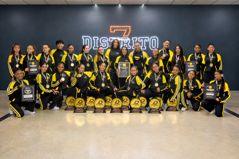 Integrantes de Distrito 7 posan con medallas, placas y trofeos de danza