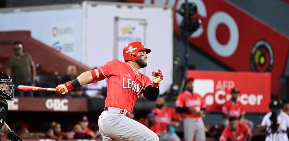 José Marmolejos realiza un swing con el uniforme rojo de los Leones del Escogido