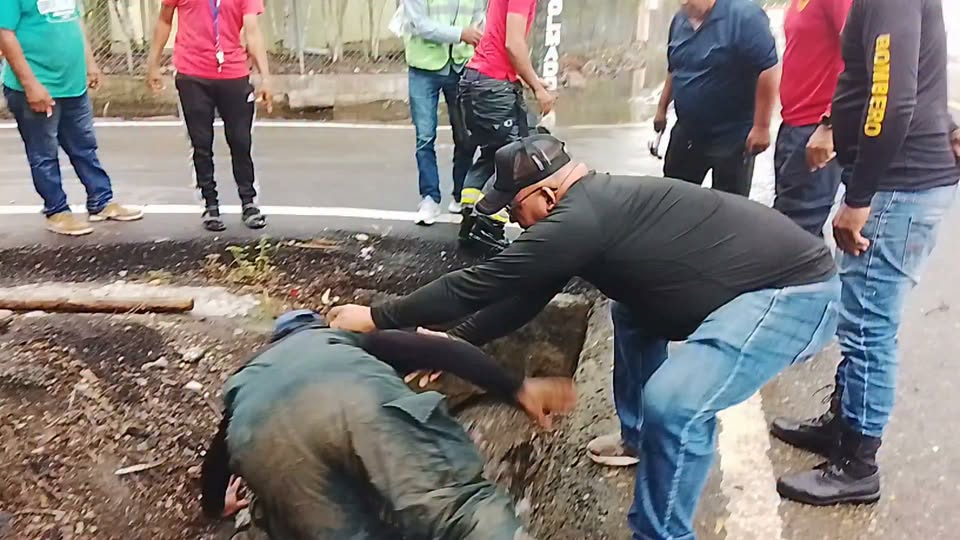 Personas trabajan en una cuneta junto a la calzada durante una jornada de limpieza